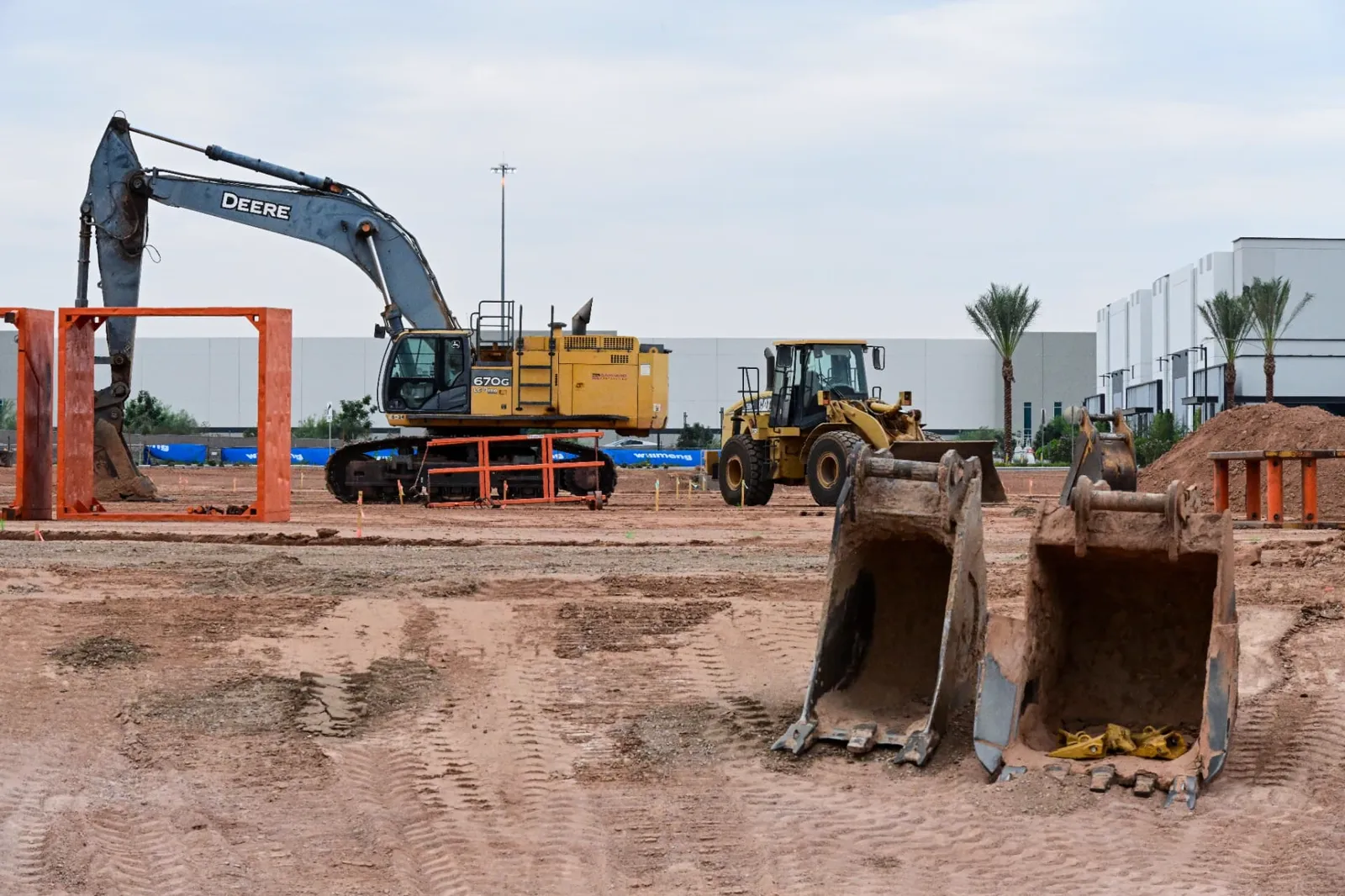 Commercial site development excavation with a Deere excavator and Caterpillar loader in Phoenix, AZ